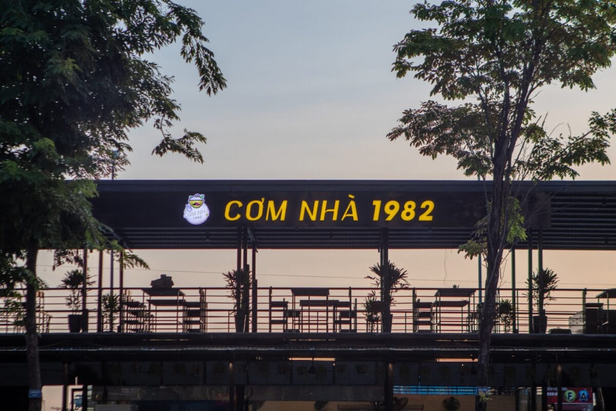 Biển hiệu quán Cơm Nhà 1982 lúc chiều tối